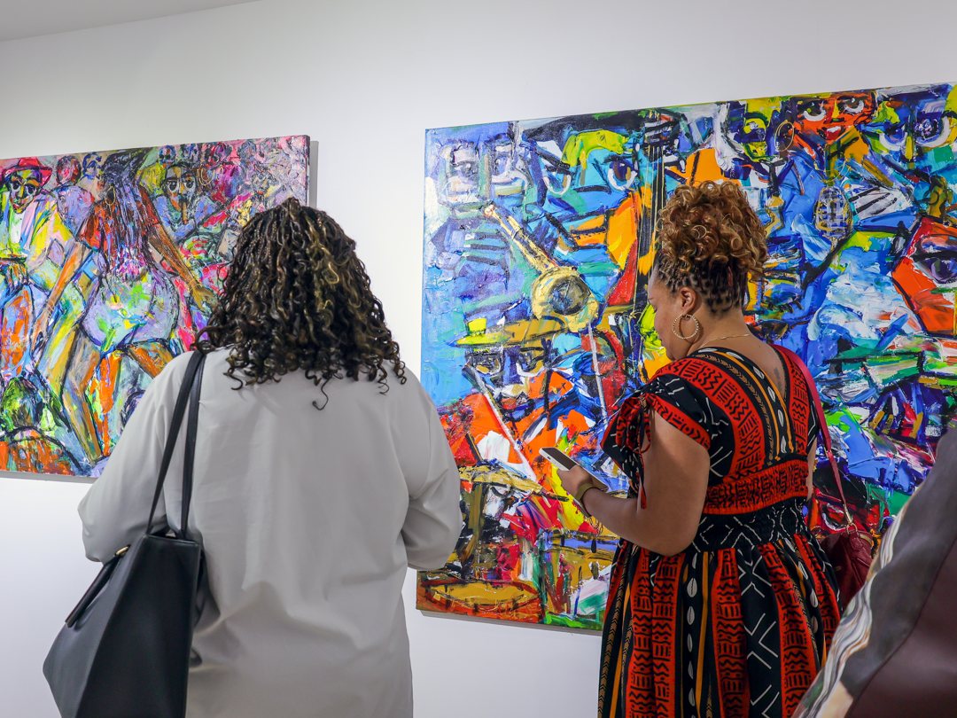 Guests in front of two of the largest canvases in the show