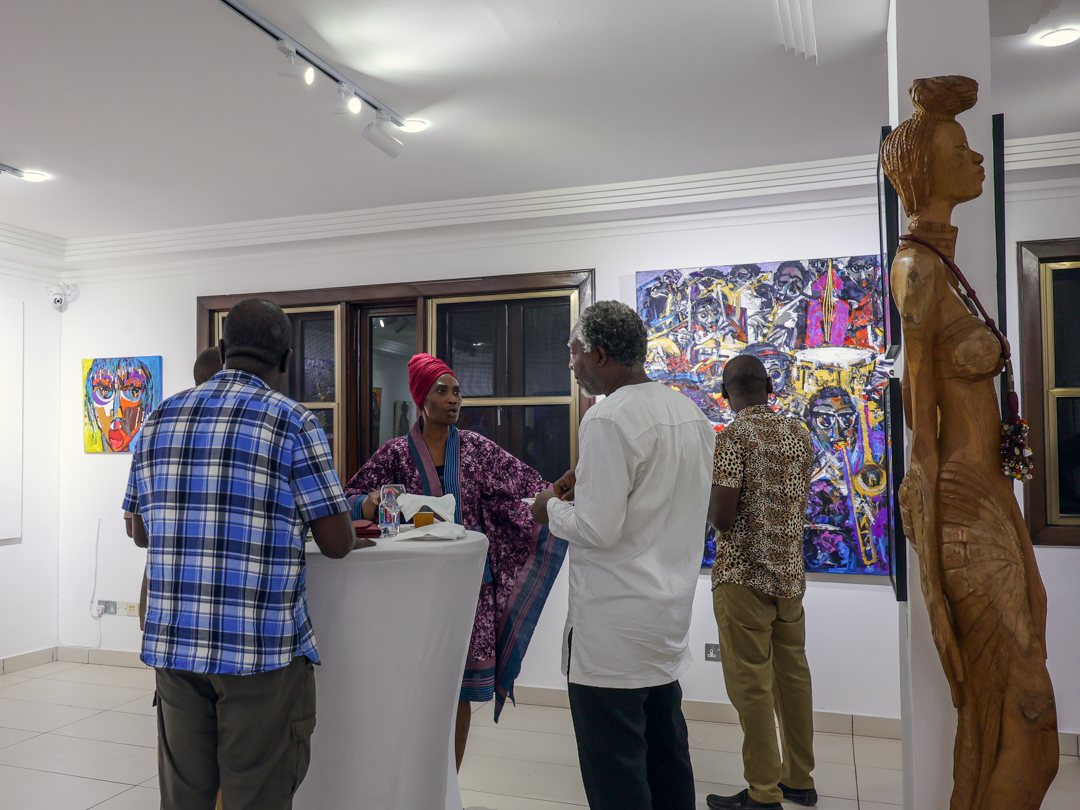 Guests talking near the carved wooden sculpture